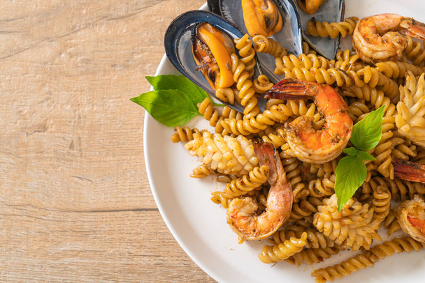 stir-fried spiral pasta with seafood and basil sauce - fusion food style - Φωτογραφία, εικόνα