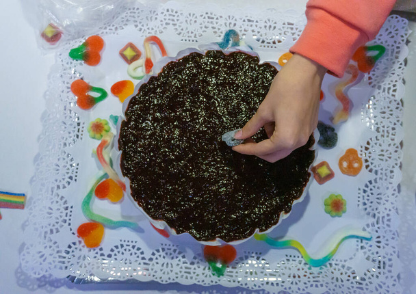 お菓子やキャンディーで自家製チーズケーキを飾る。家でのコンセプト誕生日 - 写真・画像