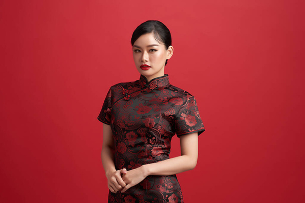 Asian chinese woman in traditional dress on red background. Chinese new year festival. - Photo, Image