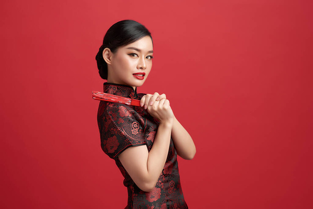 赤い背景に伝統的なドレスでアジアの中国人女性。中国の旧正月の祭り. - 写真・画像