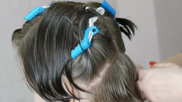De vrouwelijke handen van een kapper maken een korte bob gesneden op grijs haar en knippen de uiteinden van de klant. Speciale haarspelden voor kappers op een vrouwenhoofd - Video