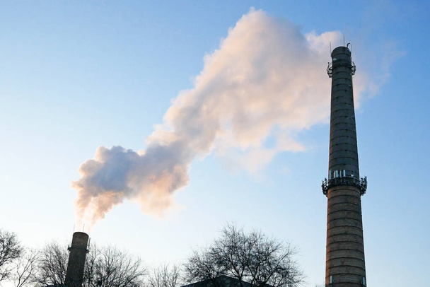 rostlinné trubky s šedým kouřem na modré obloze, chemické elektrárny věže jaderné elektrárny proti modré obloze, detailní záběr - Fotografie, Obrázek
