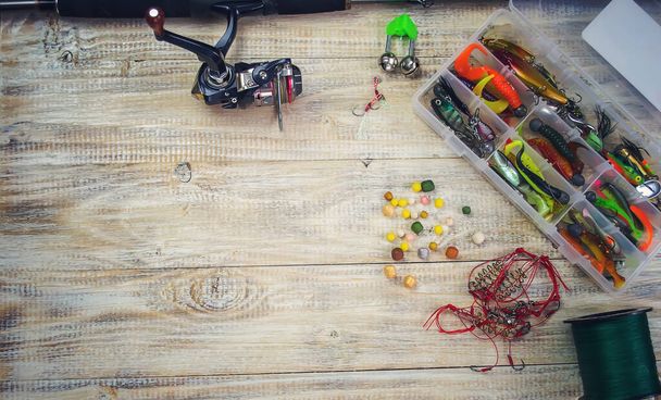 lot of colorful lures with the fishing rod on the wooden pier - Foto, afbeelding