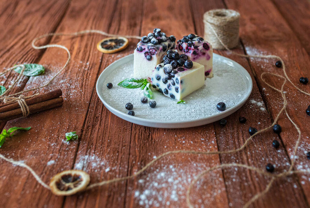 Slices of no-baking cheesecake with blueberry and mint on brown wooden table. Rustic style - Foto, Imagem