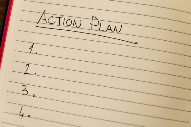Page de carnet doublée avec les mots "Plan d'action" à l'encre noire sur papier blanc, et liste numérotée. - Photo, image
