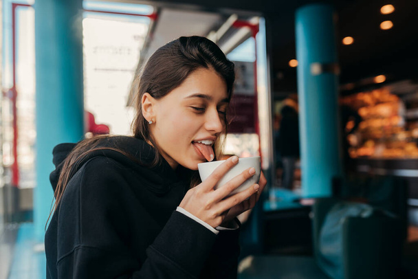 Close up portrait of pretty female drinking coffee. - Foto, imagen