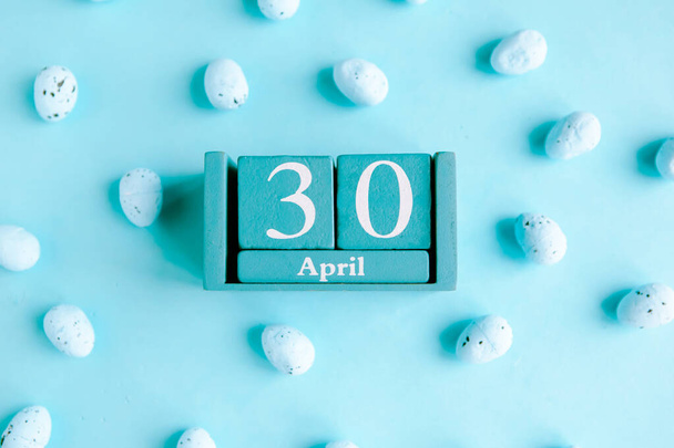 30 апреля. Голубой кубический календарь с месяцем и датой на голубом фоне. - Фото, изображение
