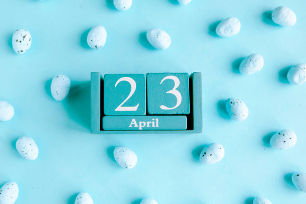 23 апреля. Голубой кубический календарь с месяцем и датой на голубом фоне. - Фото, изображение