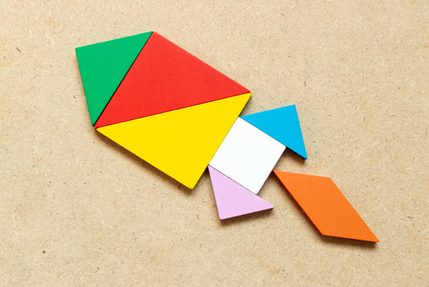 Barva tangram puzzle v raketovém nebo raketovém tvaru na pozadí dřeva - Fotografie, Obrázek