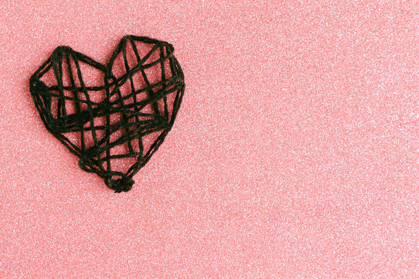 Wit gebreid handgemaakt hart op rode glitterachtergrond. Gelukkige Valentijnsdag.  - Foto, afbeelding