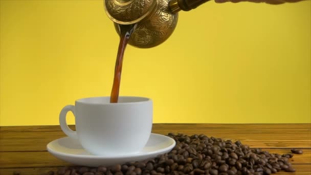 Verter el café de la cafetera turca en taza blanca - Imágenes, Vídeo