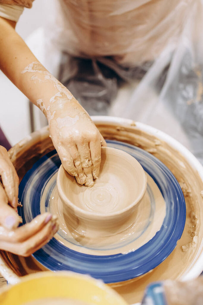 Proceso creativo de creación de cerámica por parte de la madre y las hijas. Las manos femeninas en un taller de cerámica. - Foto, Imagen