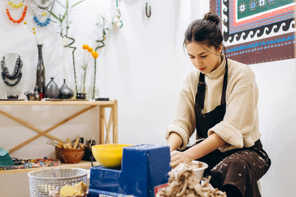 Creatief proces van het maken van aardewerk door moeder en dochters. Vrouwelijke handen in een pottenbakkerij. - Foto, afbeelding