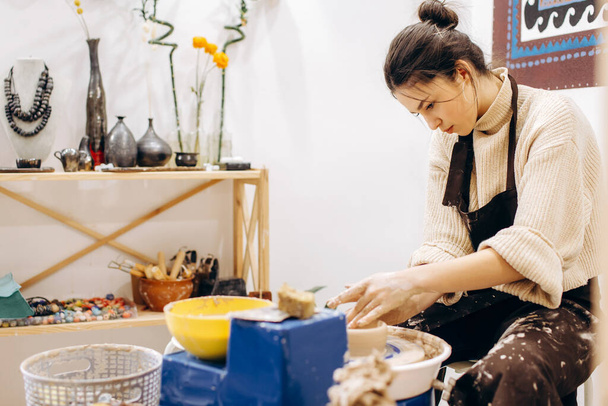 Proceso creativo de creación de cerámica por parte de la madre y las hijas. Las manos femeninas en un taller de cerámica. - Foto, imagen
