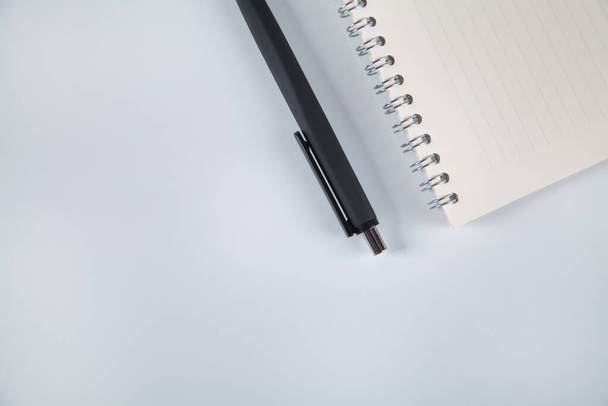 Notebook and black pen, white background. - Foto, Bild