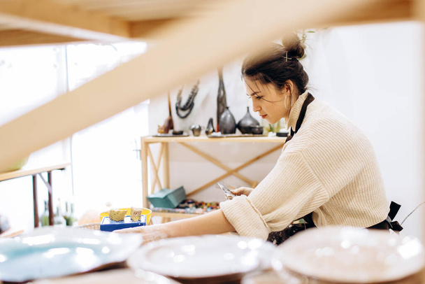 Anne ve kızlarının çanak çömlek üretme süreci. Çömlek atölyesinde çalışan kadın eller.. - Fotoğraf, Görsel