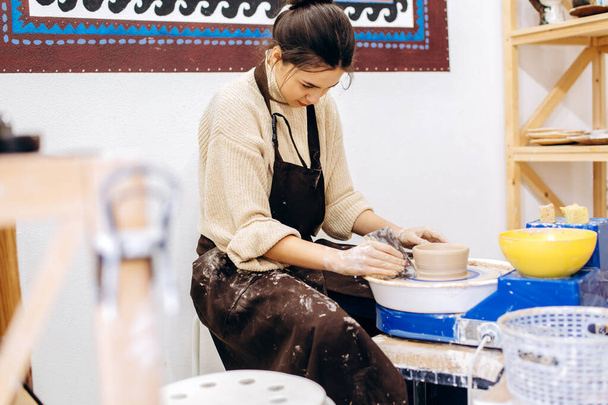 Anne ve kızlarının çanak çömlek üretme süreci. Çömlek atölyesinde çalışan kadın eller.. - Fotoğraf, Görsel