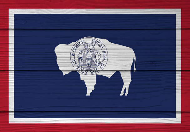 Fiber beton kaplama arka planda Wyoming bayrağı rengine boyanmış, Amerika devletleri. Amerikan bizonunun mührü mavi üzerine beyaz ve kırmızı. - Fotoğraf, Görsel