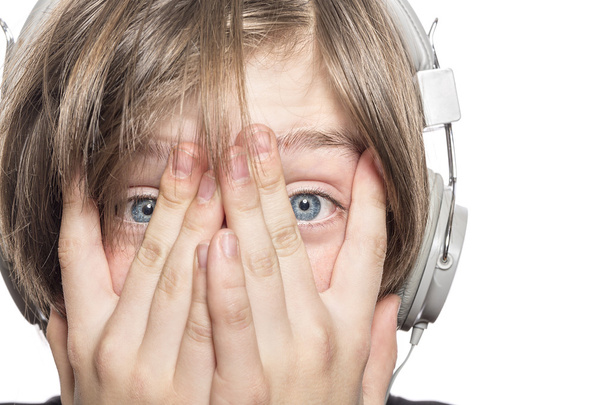 zoufalý muž teenager se sluchátky, zakrývaje si tvář s h - Fotografie, Obrázek