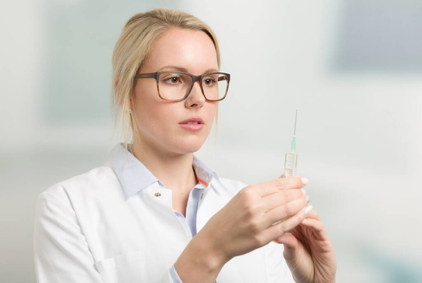 female doctor or nurse with a pulled up syringe - Фото, зображення