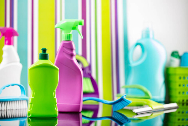 Házi és irodai takarítás téma. Színes készlet palack, klinikai folyadékok és színes tisztító készlet a háttérben formájában színes csíkok. - Fotó, kép