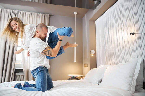 Feliz homem entretendo seu cônjuge feminino em seu quarto - Foto, Imagem