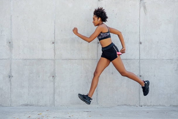 Afro athletic woman running outdoors. - Photo, Image