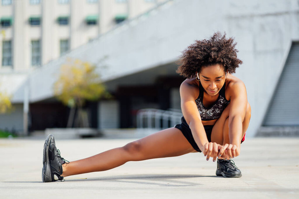 Afro athletic woman stretching before exercise. - Valokuva, kuva