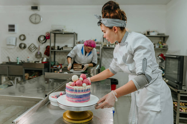お菓子工房でケーキを飾る女性のお菓子 - 写真・画像