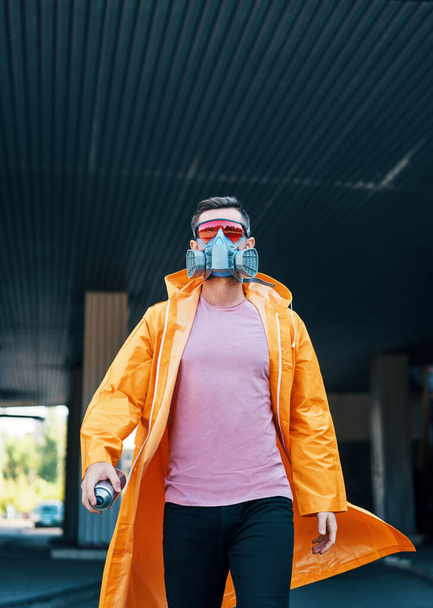 Trendy young man in respirator mask walking down the street - Foto, Imagen