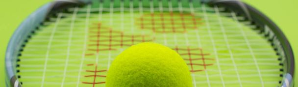 Tennisball mit Schläger auf grünem Hintergrund. Das Konzept des Sports. - Foto, Bild