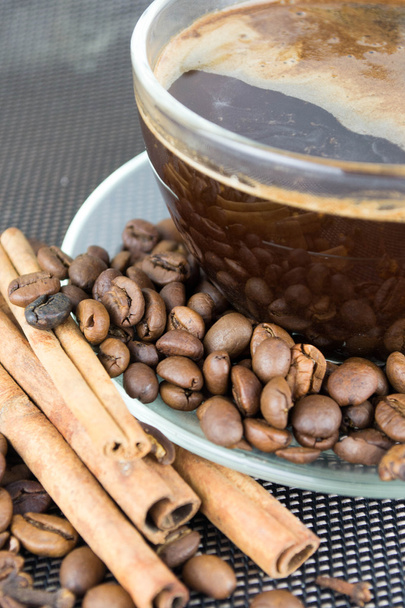 ένα φλιτζάνι καφέ με καφέ φασόλια και τα ξυλάκια κανέλας - Φωτογραφία, εικόνα