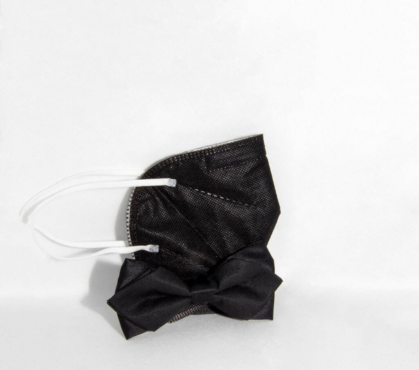 Covid fashion - un nuevo concepto de estilo de una pajarita negra y un respirador negro - Foto, imagen