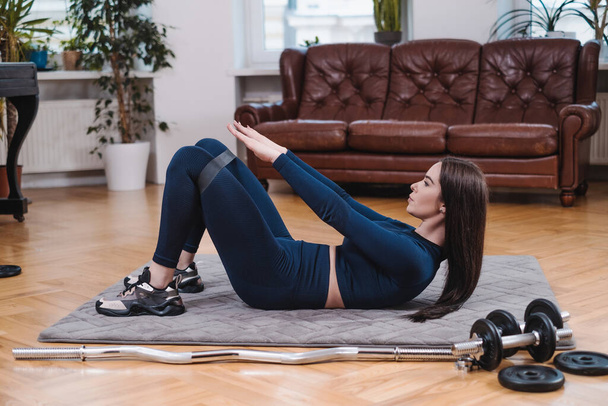 Esportista magro faz exercício físico no tapete com elástico - Foto, Imagem