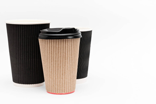 drie kartonnen kopjes voor koffie op een witte achtergrond - Foto, afbeelding