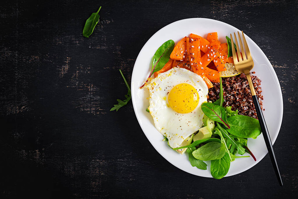 Πρωινό με κινόα, τηγανητές φέτες κολοκύθας, αβοκάντο και τηγανητό αυγό. Χορτοφαγικά, υγιεινά, διαιτητικά τρόφιμα έννοια. Πάνω όψη, αντιγραφή χώρου - Φωτογραφία, εικόνα