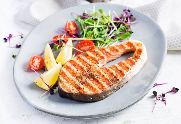 Salmon. Salmon fish steak grilled and tomatoes salad with microgreens. Healthy food. - Photo, Image