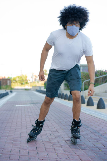 Latin man roller skating outdoors. - Fotó, kép