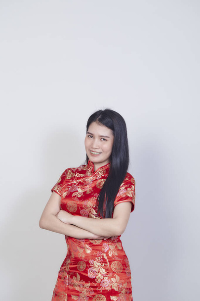 Счастливого китайского нового года. Красивая азиатка в традиционном платье Чхонсам Кипао с жестом поздравления изолированы на светло-сером фоне с копировальным пространством - Фото, изображение