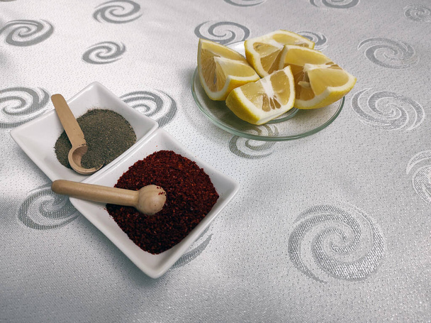 limón pimienta negra, pimiento rojo y tenedores de cuchara en la mesa, - Foto, imagen
