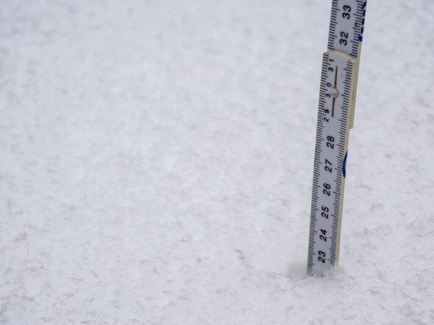 Die Schneehöhe mit einem Zollstock messen - Foto, Bild