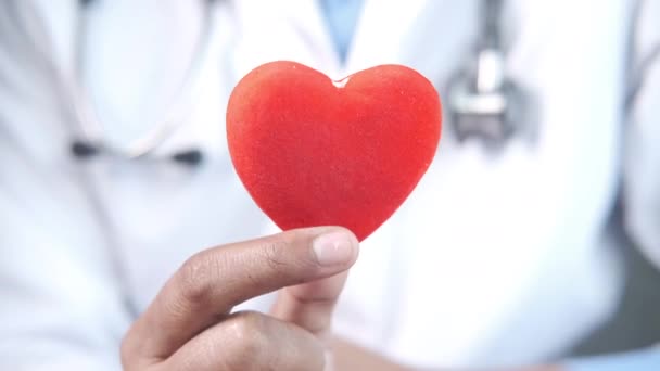  γιατρός χέρι κρατώντας κόκκινη καρδιά από κοντά  - Πλάνα, βίντεο