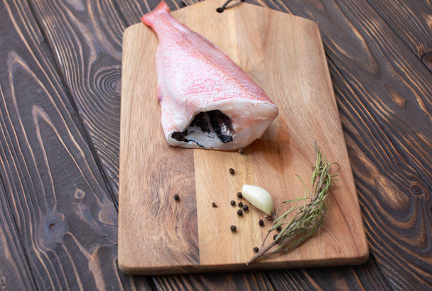 Fresh fish with spices and seasonings on cutting board - Foto, Bild