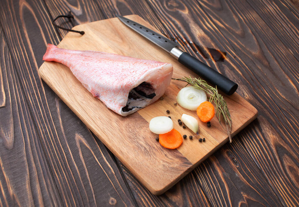 Nahaufnahme von frischem Fisch mit Gewürzen und Gewürzen auf Holztisch - Foto, Bild