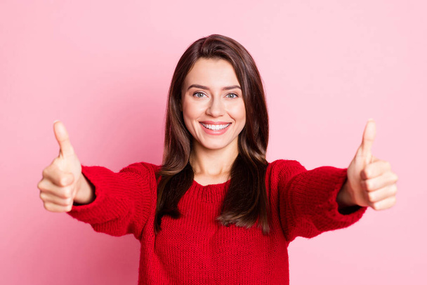 Photo of young cahrming girl raise two arms show thumb-up smile look camera wear red pullover isolated pink color background - Фото, зображення