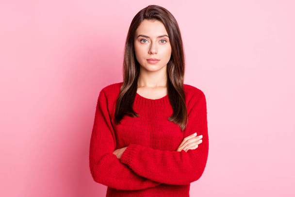 Portrait photo de jeune jolie fille calme avec le visage sérieux mains croisées portant pull rouge isolé sur fond de couleur rose - Photo, image