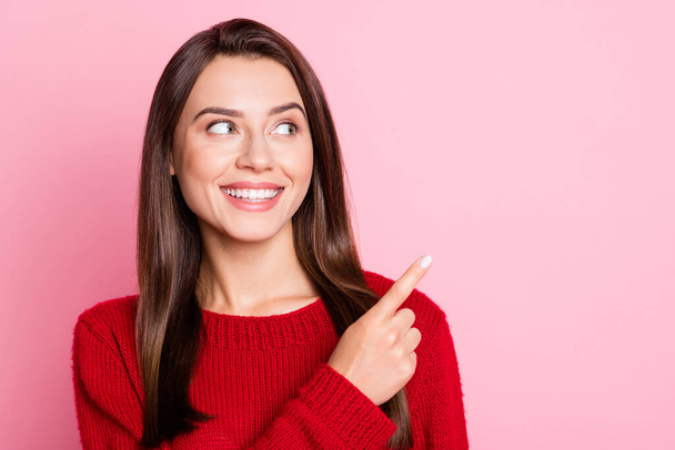 Portrait photo of happy smiling young woman with straight brunette hair looking at side pointing on blank space isolated on pink color background - Photo, Image