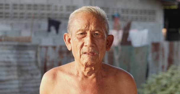 Zeitlupenszene weißhaariger asiatischer älterer Männer, die wegen des heißen Wetters keine Kleidung tragen, schlechter Zustand, über siebzig, lacht glücklich im Abendlicht des Sonnenuntergangs. - Filmmaterial, Video