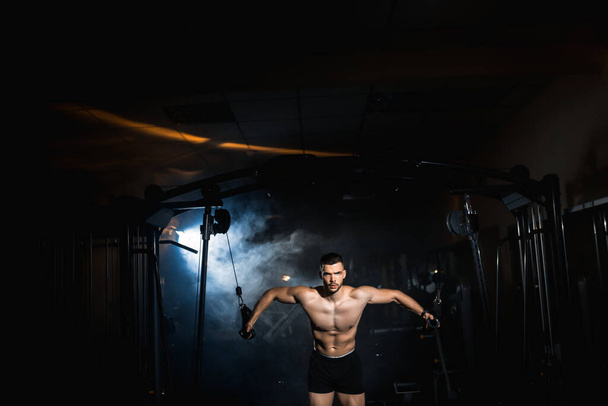 М'язова фітнес культурист робить важку вагу вправи в тренажерному залі. Спортсмен робить вправи на грудні м'язи. Високоякісна фотографія
 - Фото, зображення