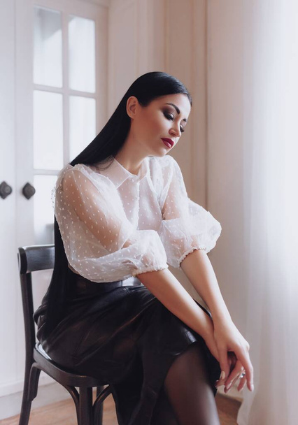 beautiful young woman in black skirt posing in studio - 写真・画像